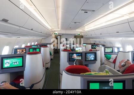 Ethiopian Airlines Airbus A350 Business Class cabin Cloud Nine with full flat bed seats. Travellers relaxing watching PTV.