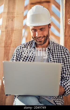 Joyous brunette field engineer working on his laptop Stock Photo