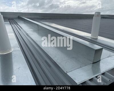 corrugated metal deck roof system with galvanised iron sheets installed on a building Stock Photo