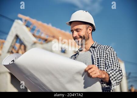 Successful male architect looking at the blueprint Stock Photo