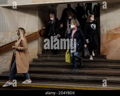 Moscow. Russia. October 5, 2020 People passengers with protective masks on their faces inside the metro station descend the stairs. Preventive Stock Photo