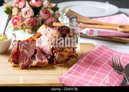 grilled knuckle of pork with mustard on a wooden cutting board, german schweinshaxe Stock Photo