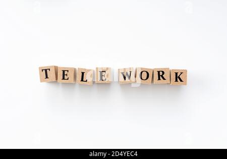 A wooden block with the word tele work written on it on a white background Stock Photo