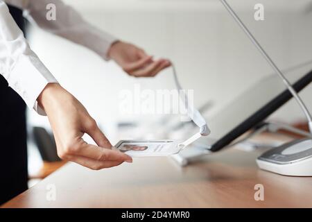 Close up of unrecognizable secretary putting place card on desk while preparing business conference in office, copy space Stock Photo