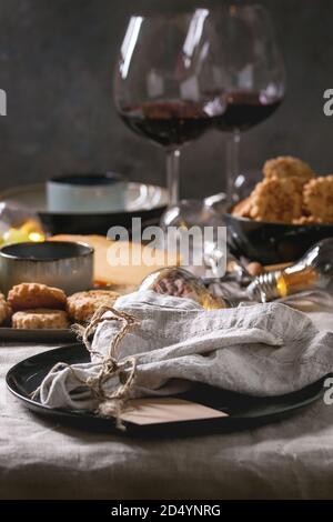 Home dinner table set with wine, cheese plate, appetizers and empty plate with cloth napkin. Stock Photo