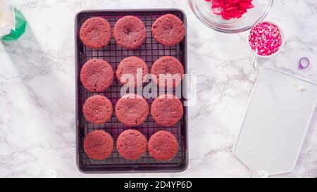 Flat lay. Step by step. Cooling red velvet cupcakes on a kitchen drying rack. Stock Photo