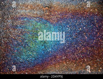 Rainbow colours from spilt oil on a wet road Stock Photo