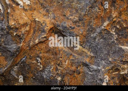 The surface of the natural stone reddish color with cracks and prints Stock Photo