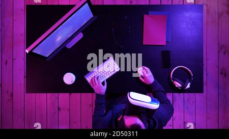 Young bearded man in VR-headset playing a game. Stock Photo
