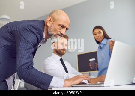 Group of business partners looking at laptop screen for presentation of new project Stock Photo