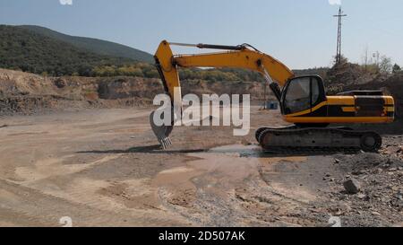 Yellow digger machine. Excavator with a shovel for digging. Sand and mud everywhere. Stock Photo