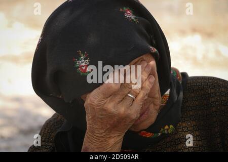 An old woman cries because of the loss of her son, tears streaming down an elderly woman's face, Wrinkles on an old woman's face, close up Stock Photo