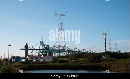 Doel, Belgium, October 10, 2020, cranes and electricity towers and radar tower near the port of Antwerp Stock Photo