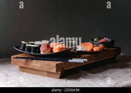 https://l450v.alamy.com/450v/2d50a9k/sushi-set-nigiri-and-sushi-rolls-on-japanese-wooden-serving-board-with-soy-sauce-chopsticks-on-grey-linen-table-cloth-japan-menu-2d50a9k.jpg