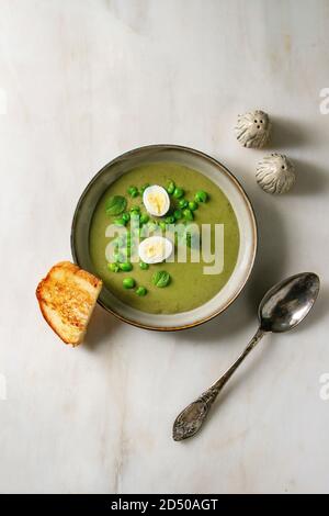 Creamy white asparagus soup bowls that sit on a warm wood background ...