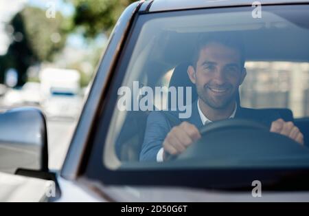 Smiling young man driving his car in the city Stock Photo