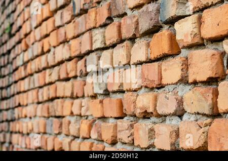 Red brick wall in receding perspective. Geometric composition of rectangular clay bricks. Multitasking background. Without anyone. Stock Photo
