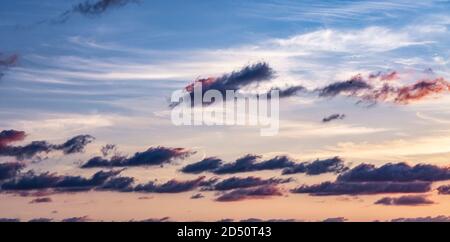 Sky in the pink shades of the sunset with floating clouds. Natural background. Copy space Stock Photo