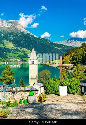 Submerged Bell Tower of Curon and a cemetery on Lake Reschen in South Tyrol, Italy Stock Photo