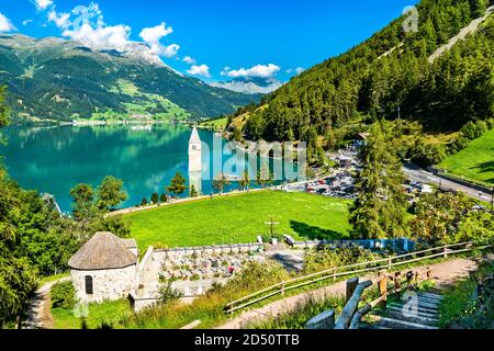 Submerged Bell Tower of Curon and a cemetery on Lake Reschen in South Tyrol, Italy Stock Photo