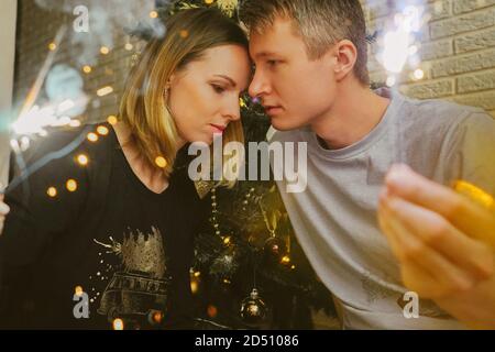 Family couple with sparklers and Christmas tree. Stock Photo
