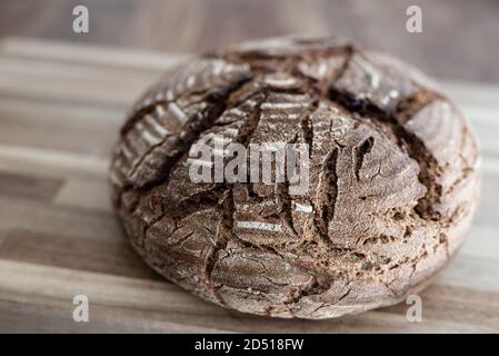 close-up of freshly baked homemade rye sourdough bread on wooden table Stock Photo