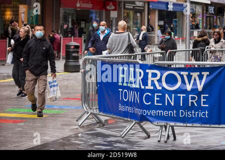 London, UK.  12 October 2020. Shoppers wearing facemasks pass through Harrow town centre.  It is reported that five London boroughs had more than 100 new COVID-19 cases per 100,000 population in the week to October 8 — Richmond, Hackney, Ealing, Redbridge and Harrow.  As the UK experiences a rise in the number COVID-19 cases nationwide, Boris Johnson, Prime Minister is announcing in the House of Commons a new three-tier local lockdown system to tackle the spread of the virus.    Credit: Stephen Chung / Alamy Live News Stock Photo