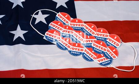 Many I voted today stickers on face mask against american flag. Coronavirus elections. Stock Photo
