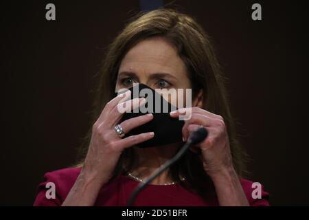 Washington, United States. 12th Oct, 2020. Supreme Court nominee Judge Amy Coney Barrett adjusts her mask at her Senate Judiciary Committee confirmation hearing on Capitol Hill on October 12, 2020 in Washington, DC. The hearings are expected to last four days. If confirmed, Barrett will replace Justice Ruth Bader Ginsburg, who died last month. Pool photo by Win McNamee/UPI Credit: UPI/Alamy Live News Stock Photo