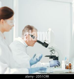 pharmacists from all over using microscope in the laboratory. Stock Photo