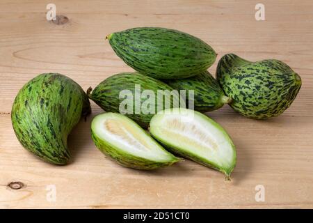 Fresh whole and halved Kelek fruit, unripe melon, on wooden background close up Stock Photo