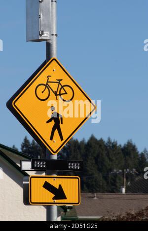 yellow dimond biking lane sign on the side of the road Stock Photo