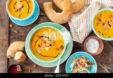Spicy vegan pumpkin soup with roasted coconut flakes Stock Photo