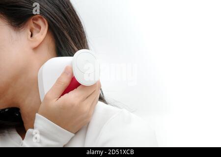 electric arm, neck and shoulder massage machine on women shoulder, closeup, healthcare and medicine concept Stock Photo