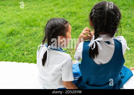 two little asian girls sisters hugging happy post in school uniform, back to school concept Stock Photo