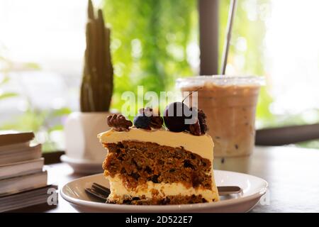 Piece of carrot fruit cake and ice coffee on coffee cafe, close up side view Stock Photo