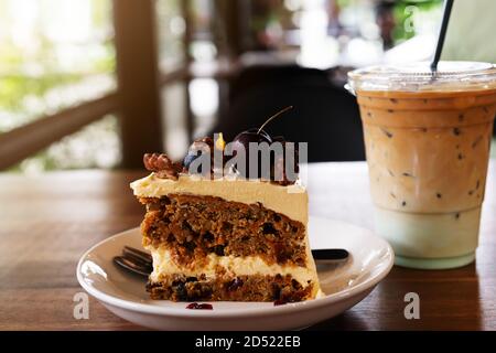 Piece of carrot fruit cake and ice coffee on coffee cafe, close up side view Stock Photo