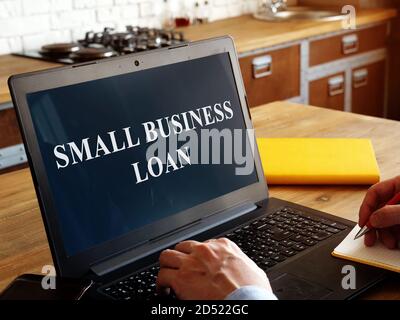 Small business loan concept. Businessman reads a text on laptop. Stock Photo