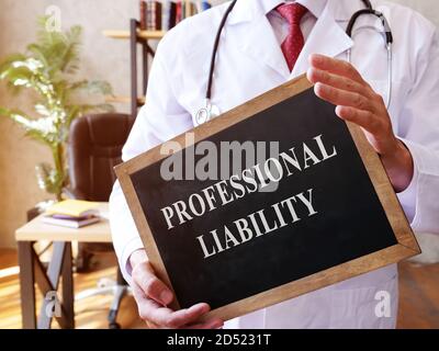 The doctor holds a sign with the Professional liability inscription. Stock Photo