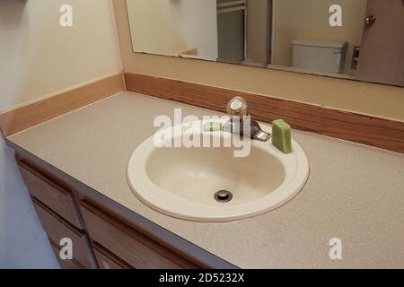 beige bathroom counter old finishes and green soap Stock Photo