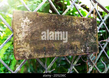 wooden sign board hanging on steel fence Stock Photo