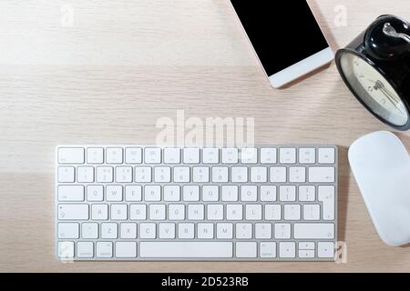 office table with computer keyboard, mouse, smartphone and alarm clock. topview, copy space Stock Photo