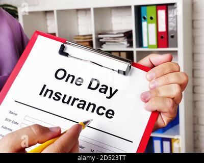 One day insurance for car. The insurer offers to sign the papers. Stock Photo