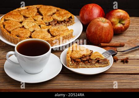 Homemade apple pie with cinnamon and cup of tea on wooden table. Shallow focus. Stock Photo