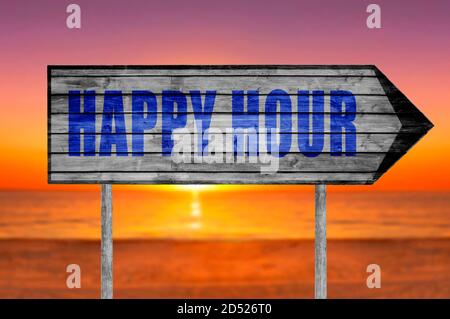 Happy Hour wooden sign with a beach on background Stock Photo