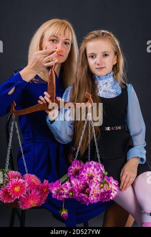 Mother and daughter are holding scales, on the bowls of which are flowers. Astrological idea for the zodiac sign Libra Stock Photo