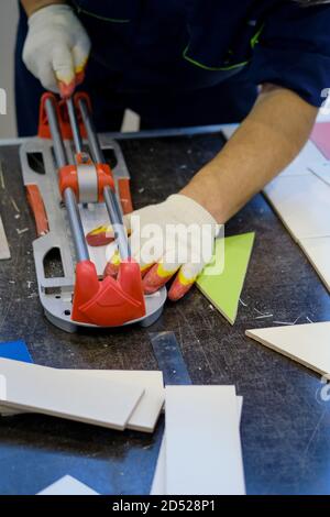 A man cuts a tile on the table, close-up Stock Photo