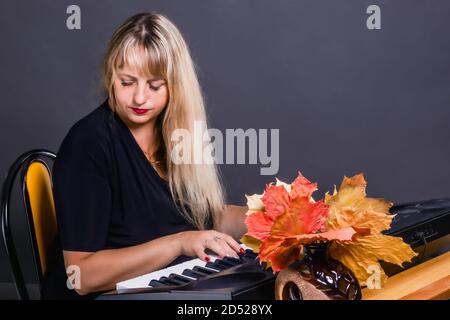 Autumn mood in music performed by a woman on a synthesizer Stock Photo