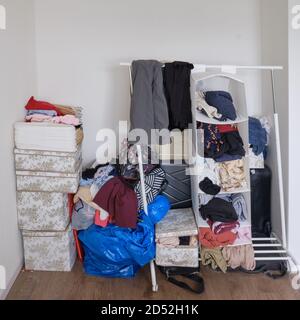 A room cluttered with female and male clothes, no wardrobe Stock Photo