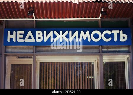 The inscription Real estate in Russian above the entrance to the agency of realtors. Translation 'Real Estate' Stock Photo
